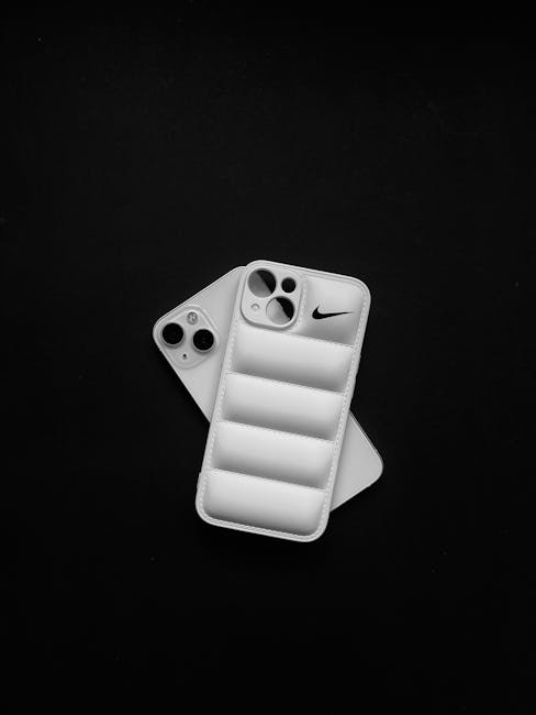 Close-up of a smartphone with a quilted protective case arrangement on black background.